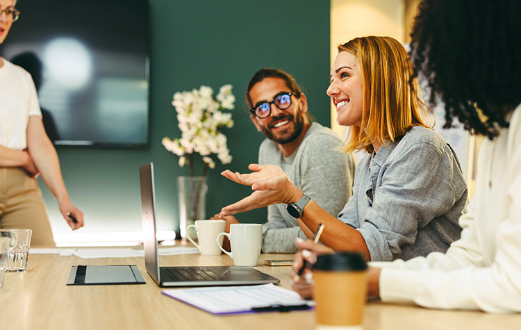 Young employees are sitting in a meeting, smiling