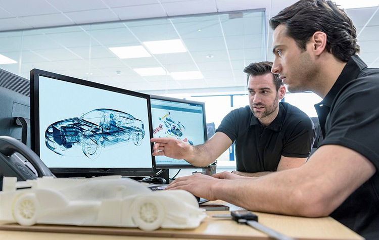 Colleagues work on new car models in front of the screen