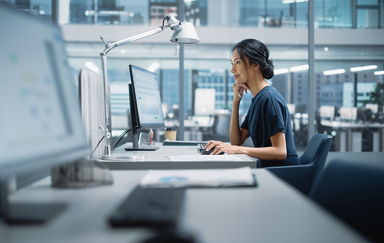 Bank employee sits in front of the computer and checks figures