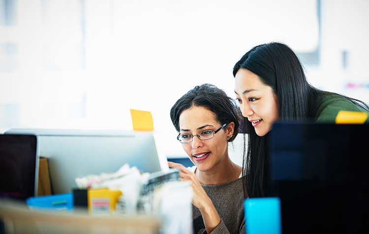 Two colleagues are looking at something on the screen