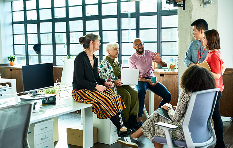 Various staff members are chatting in an open-plan office