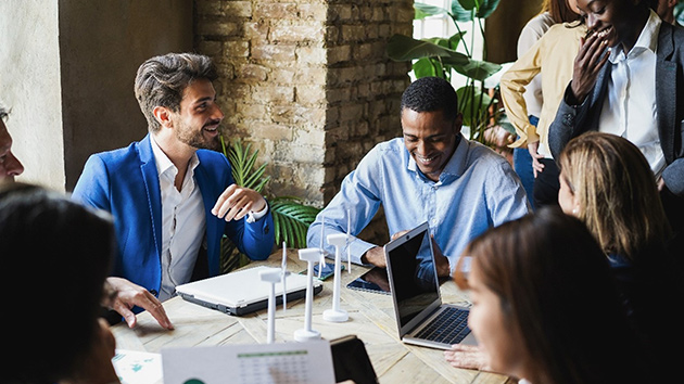 Ten employees are sitting together at a meeting