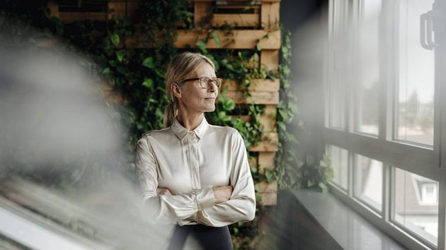 Blonde Frau schaut aus einem Fenster